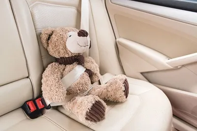 Mainan anak-anak diikat di dalam mobil.